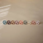 Row of colorful pacifiers on a beige background