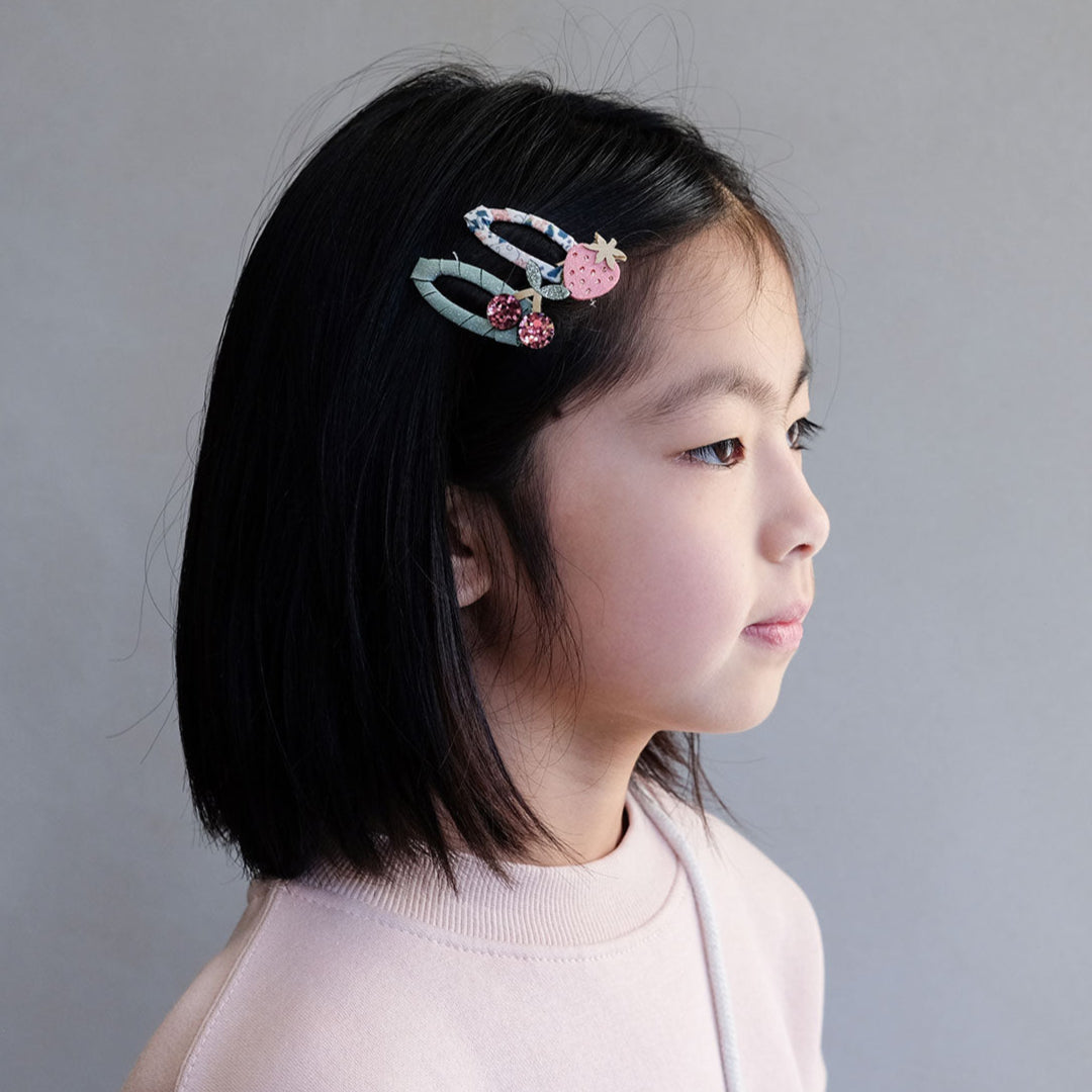 Young girl with a decorative hair clip on a plain background