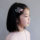 Young girl with a decorative hair clip on a plain background