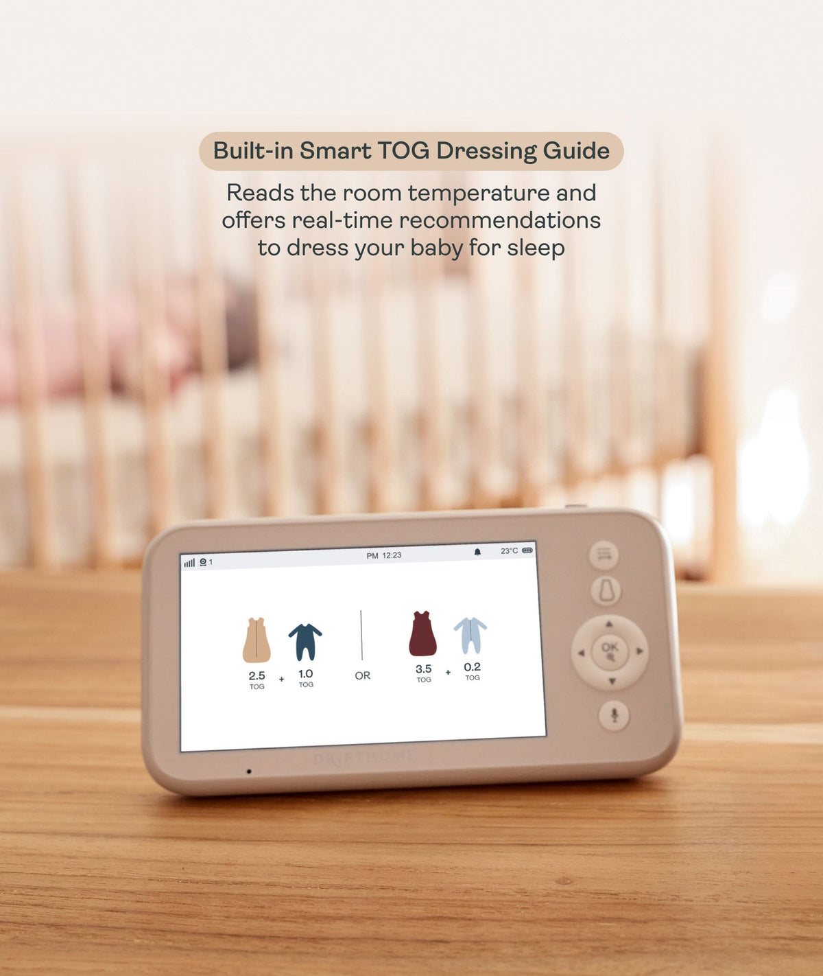 Baby monitor with screen displaying temperature and clothing recommendations on a wooden surface.
