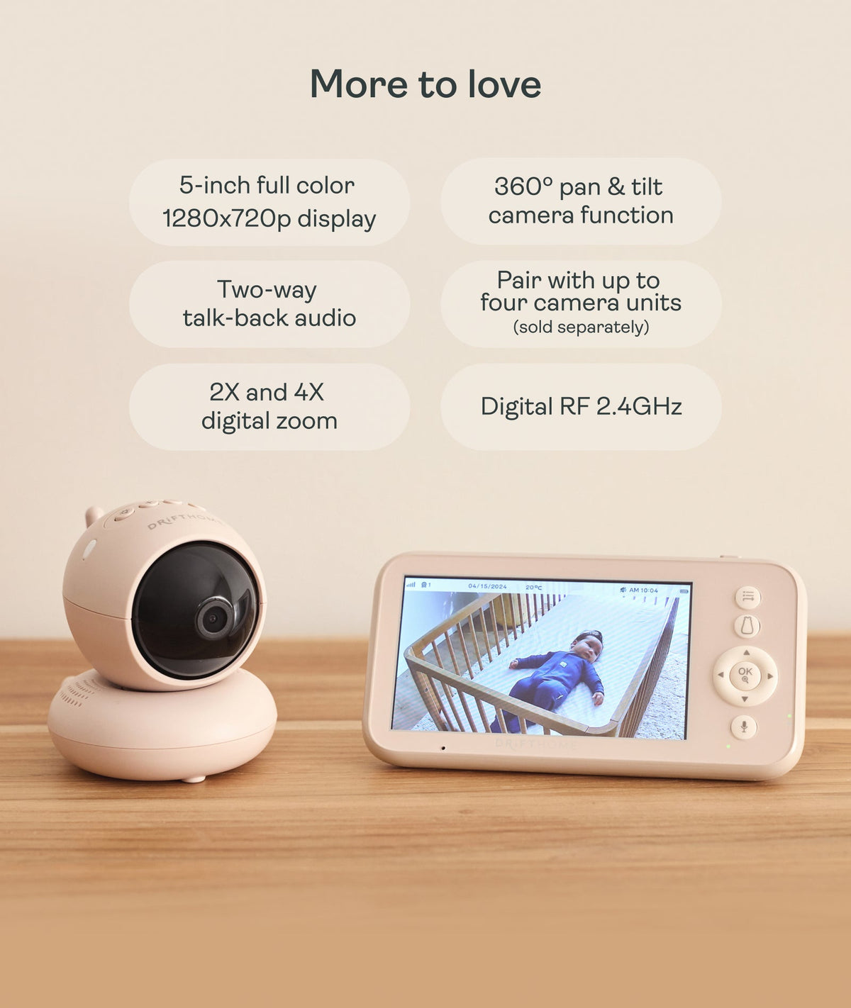 Baby monitor with display and camera on a wooden surface, featuring text about its features.