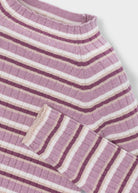 Close-up of a purple and white striped fabric with a pocket detail on a light gray background