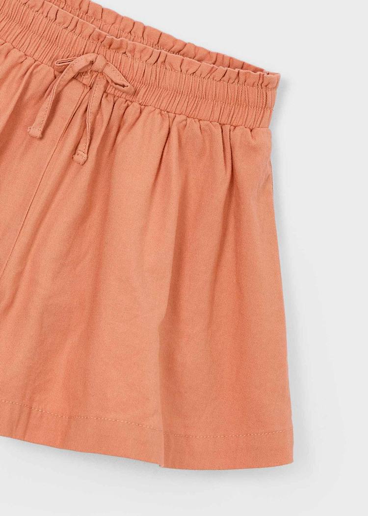 Coral-colored shorts with a drawstring on a white background