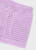 Close-up of a textured purple fabric with a white background