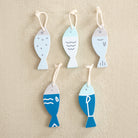Set of five fish-shaped decorative items on a beige background