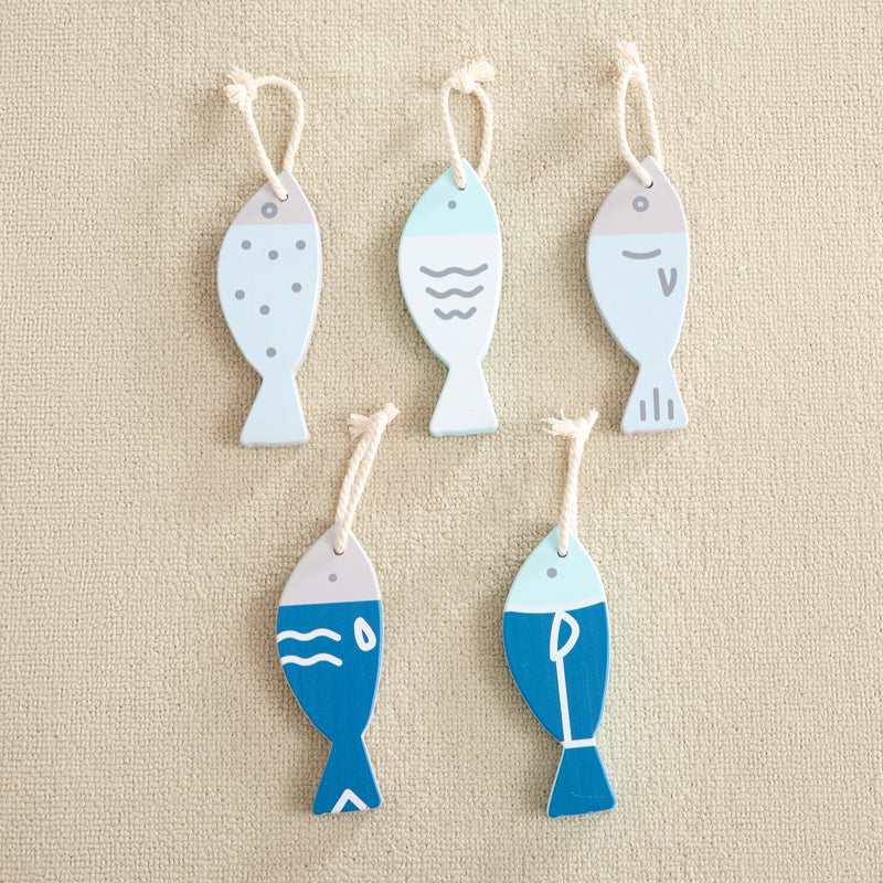 Set of five fish-shaped decorative items on a beige background