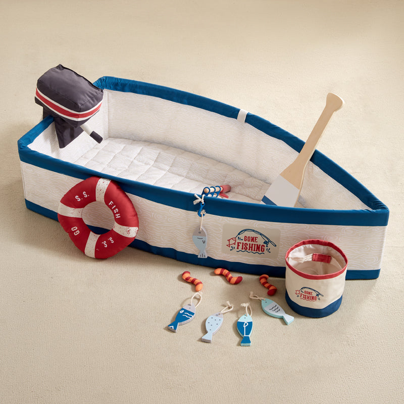 Toy boat set with fishing accessories on a beige background