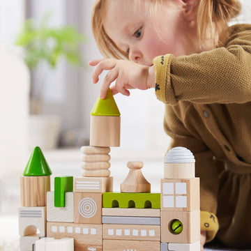 Child playing with wooden building blocks in a home setting