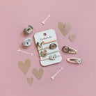 A set of dog-themed hair accessories displayed on a pink background with decorative paper hearts and bones. The set includes a white display card labeled 'Rockahula' with four elastic hair ties featuring dog faces, plus three matching hair clips.