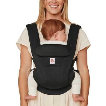 Woman carrying a baby in a black baby carrier on a white background