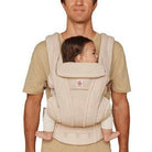 Person using a baby carrier with a baby inside on a plain background