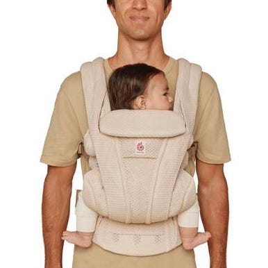 Person using a baby carrier with a baby inside on a plain background