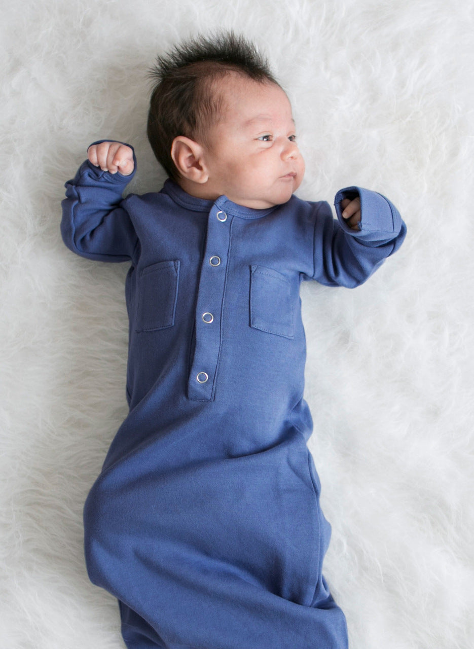 Baby wearing a blue onesie lying on a white surface