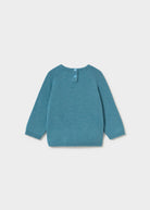 A teal blue knit sweater for toddlers, featuring long raglan sleeves and a small button closure at the collar, displayed on a light gray background.