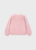 A light pink knit sweater shown from the back, featuring a delicate geometric lace-knit pattern across the upper back, set against a solid light gray background.