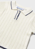 Close-up of a ribbed knit sweater with button details on a white background