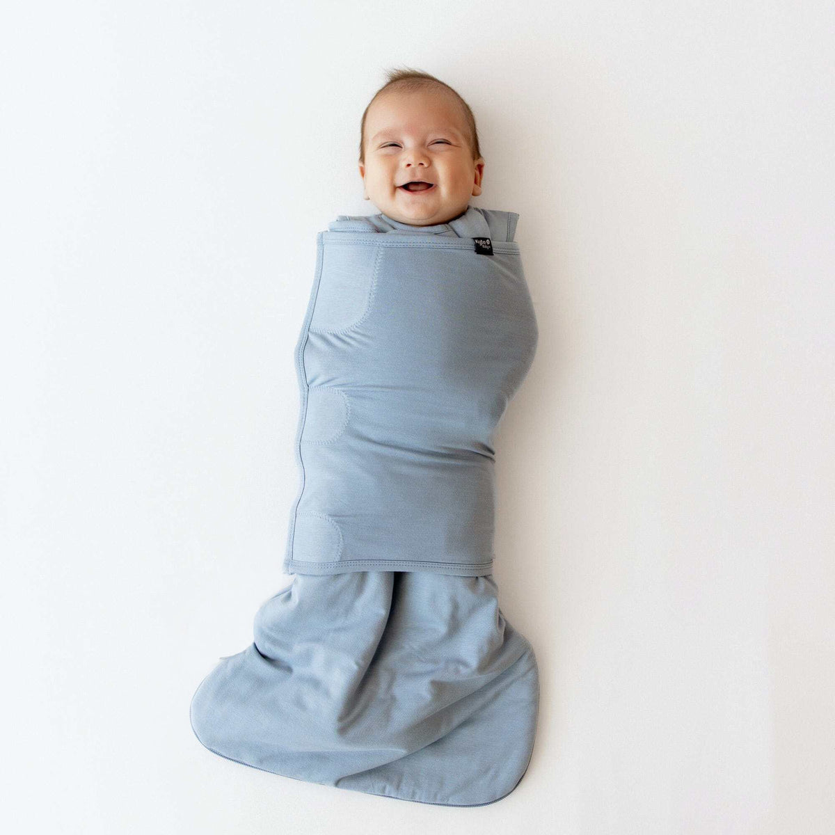 Baby wrapped in a blue swaddle on a white background