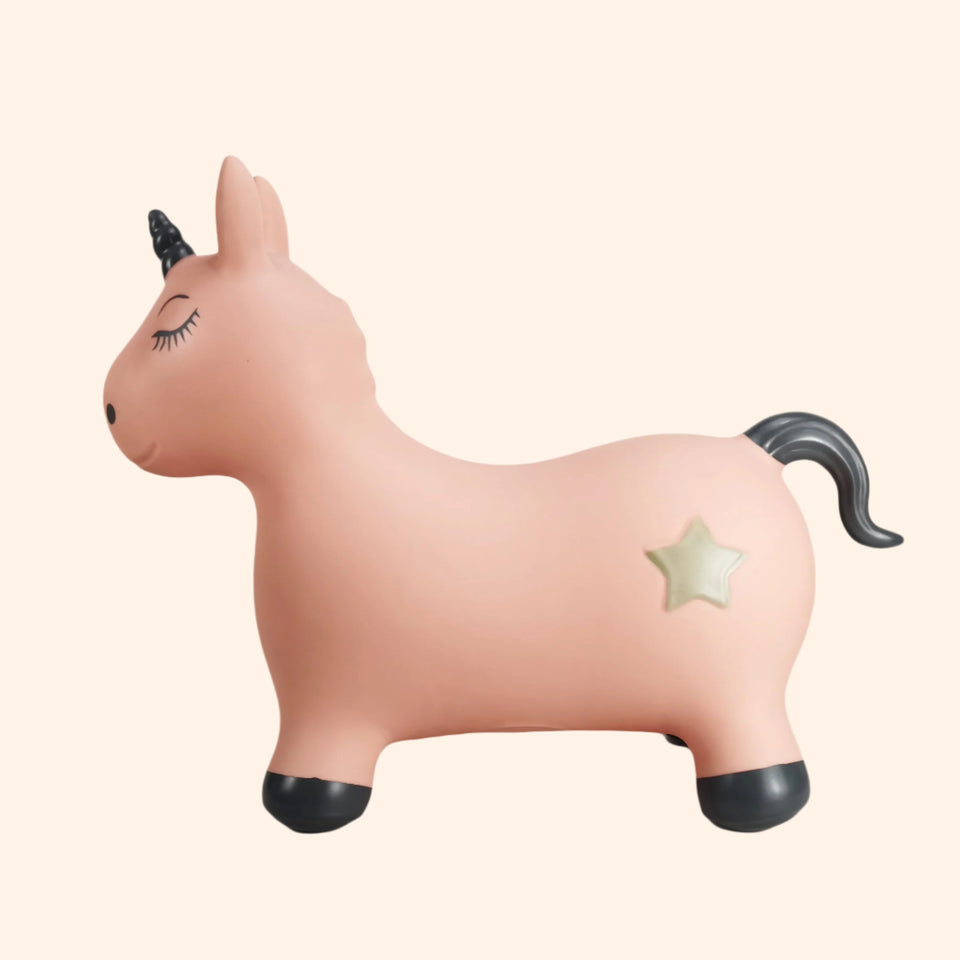 Pink unicorn toy with a star on a white background
