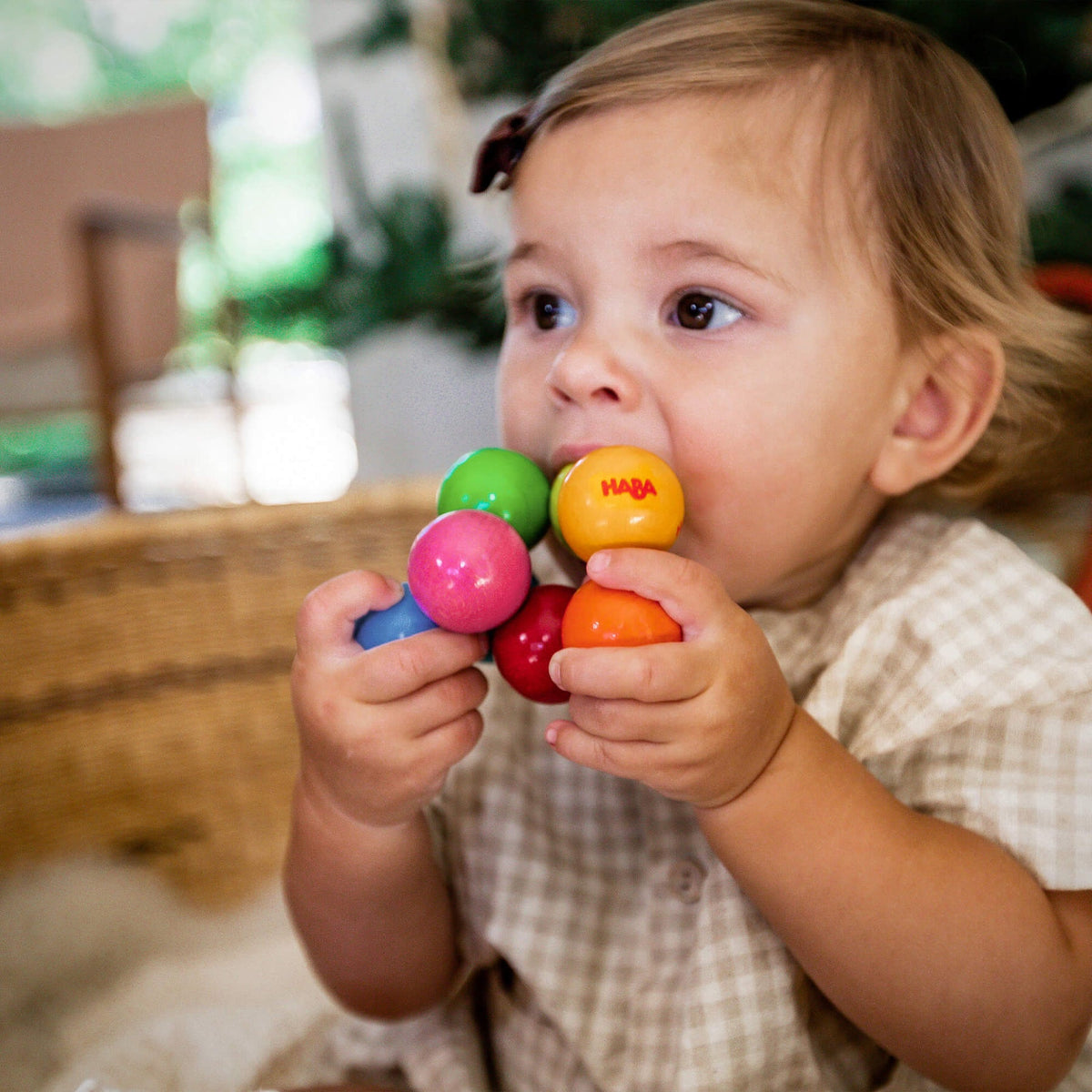 Child holding and playing with colorful Haba toy