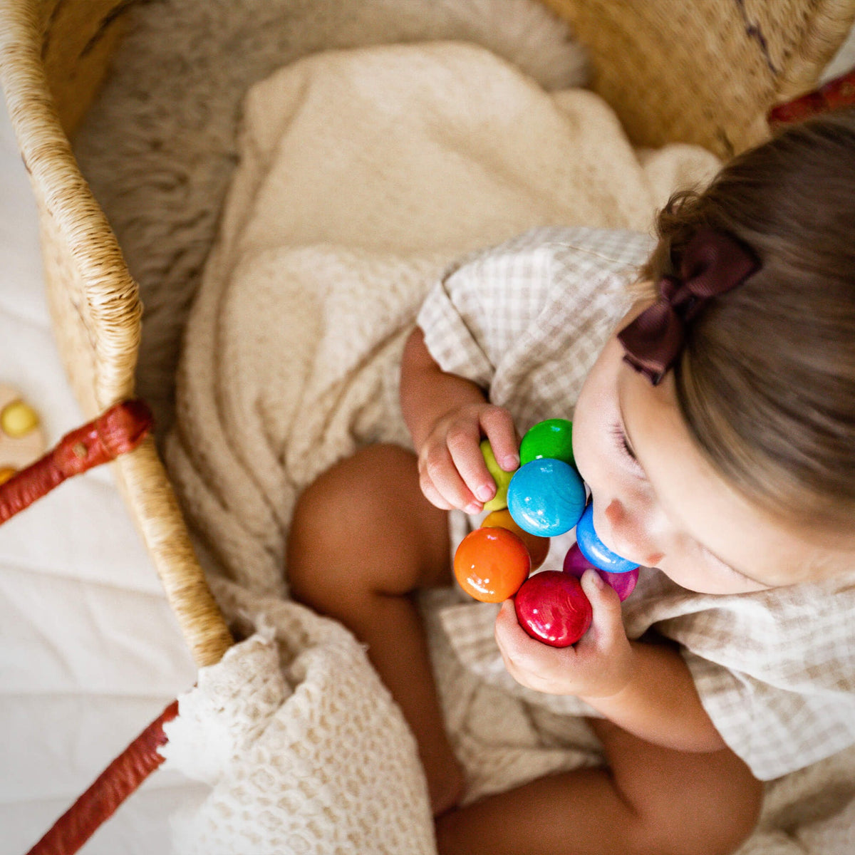 Child playing with colorful toys in a crib