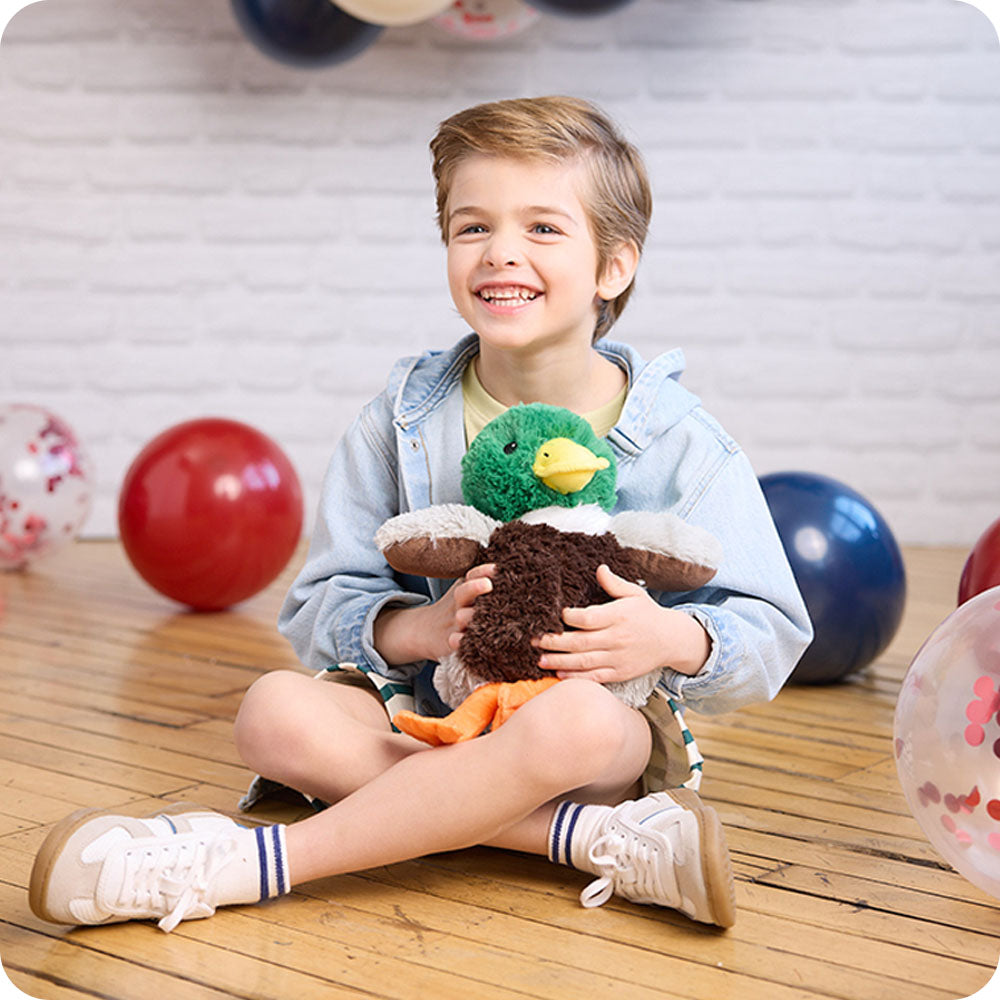 Child holding a plush toy with colorful balls in the background