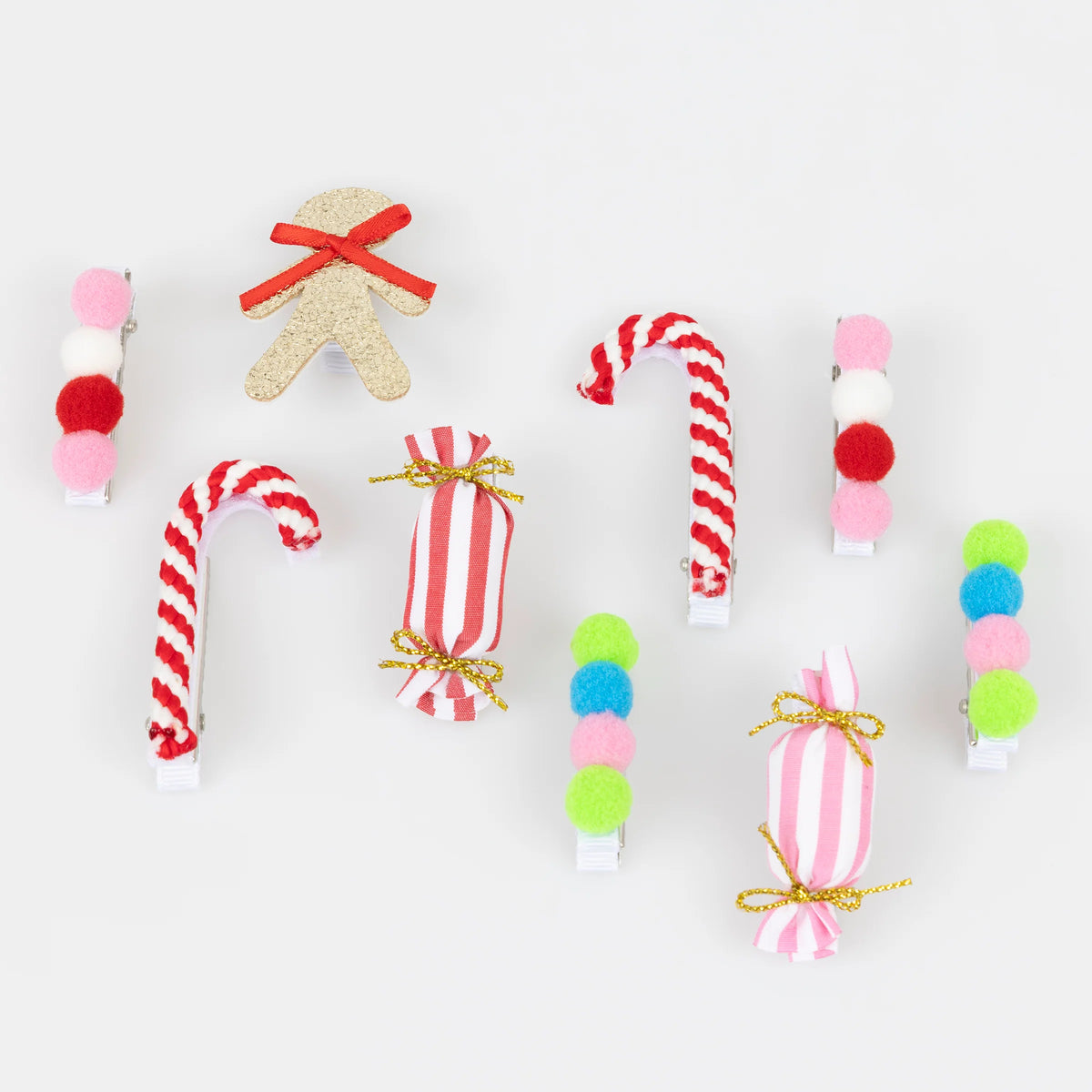 A set of Christmas-themed hair clips arranged on a plain white background, including candy cane, gingerbread man, striped candy, and pom-pom designs in red, white, pink, green, blue, and gold.