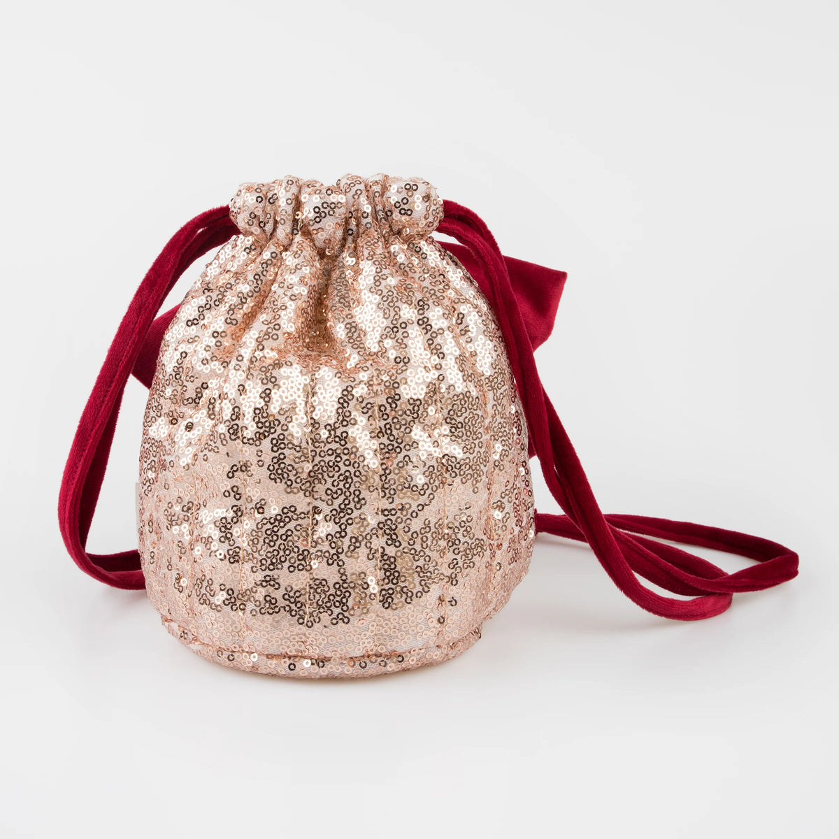 A small rose gold sequined drawstring pouch bag with a deep red velvet shoulder strap, photographed on a clean white background.