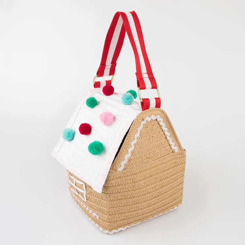 Gingerbread house-shaped bag with pom-pom details on a white background