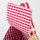Red and white checkered bag with a straw handle on a light gray background