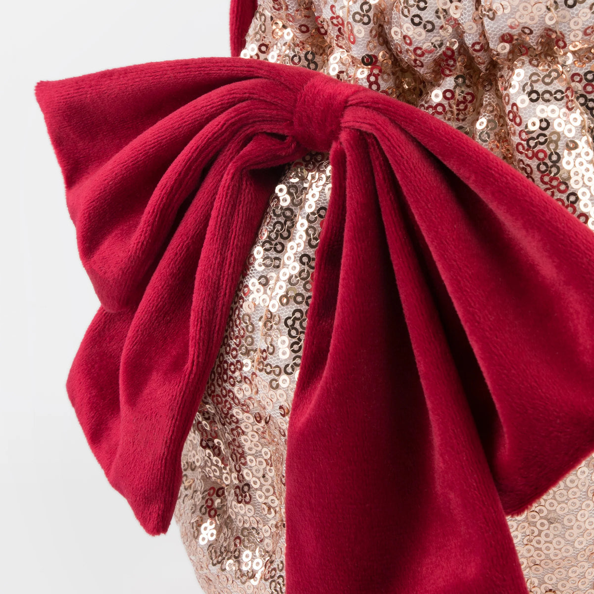 Close-up of a red bow on a sequined fabric background