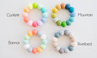 Four colorful beaded bracelets labeled 'Confetti', 'Mountain', 'Banner', and 'Riverbed' on a white background.