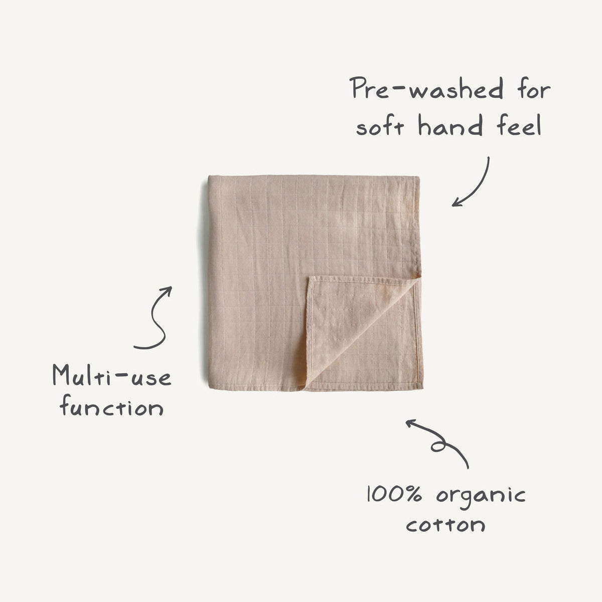 Folded beige towel with text indicating pre-washed feel, multi-use function, and 100% organic cotton on a white background.