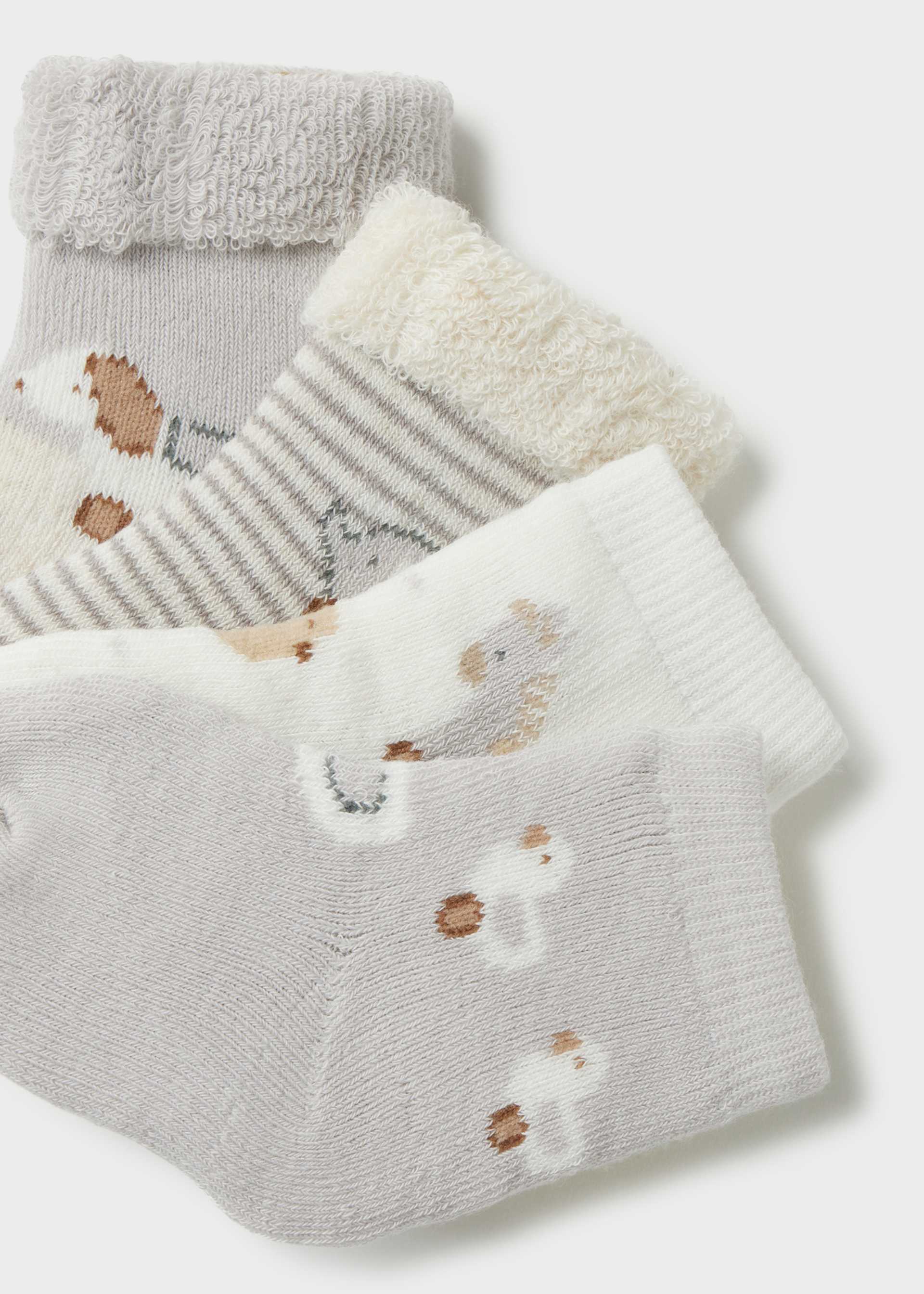 Set of baby socks with hedgehog design on a light gray background