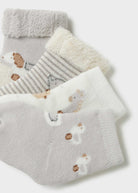 Set of baby socks with hedgehog design on a light gray background