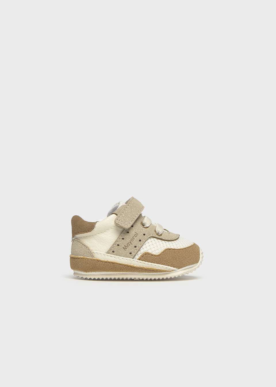 Beige and white children's sneakers on a light gray background
