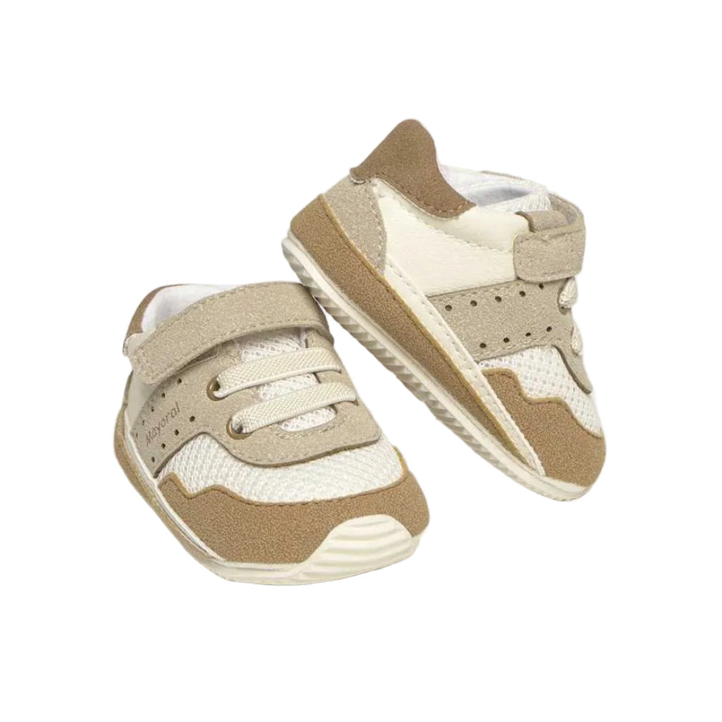 Pair of beige and white baby shoes on a white background