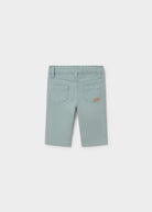 A pair of light sage green denim shorts for kids, shown from the back on a neutral light gray background.