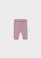 A pair of baby knit pants in a dusty rose pink color, featuring an elastic waistband and ribbed ankle cuffs, shown flat against a light gray background.