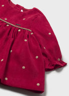Red dress with gold polka dots on a white background