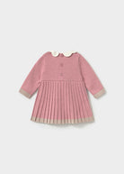 A pink long-sleeve knit dress for toddlers, featuring a pleated skirt, a white Peter Pan collar, and beige ribbed trim on the cuffs and hem.