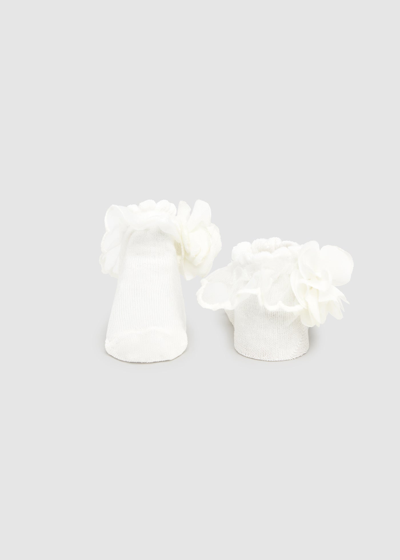 White floral earrings on a light gray background