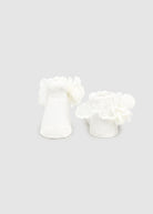 White floral earrings on a light gray background