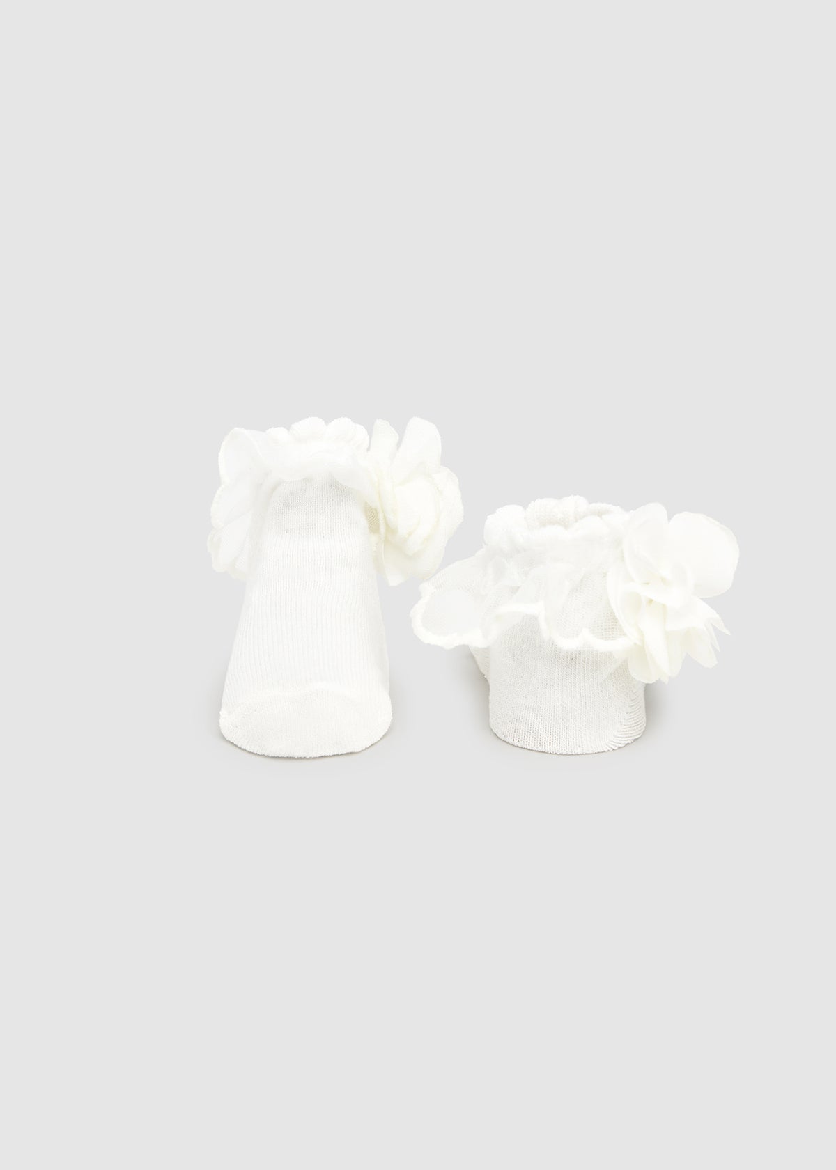 White floral earrings on a light gray background