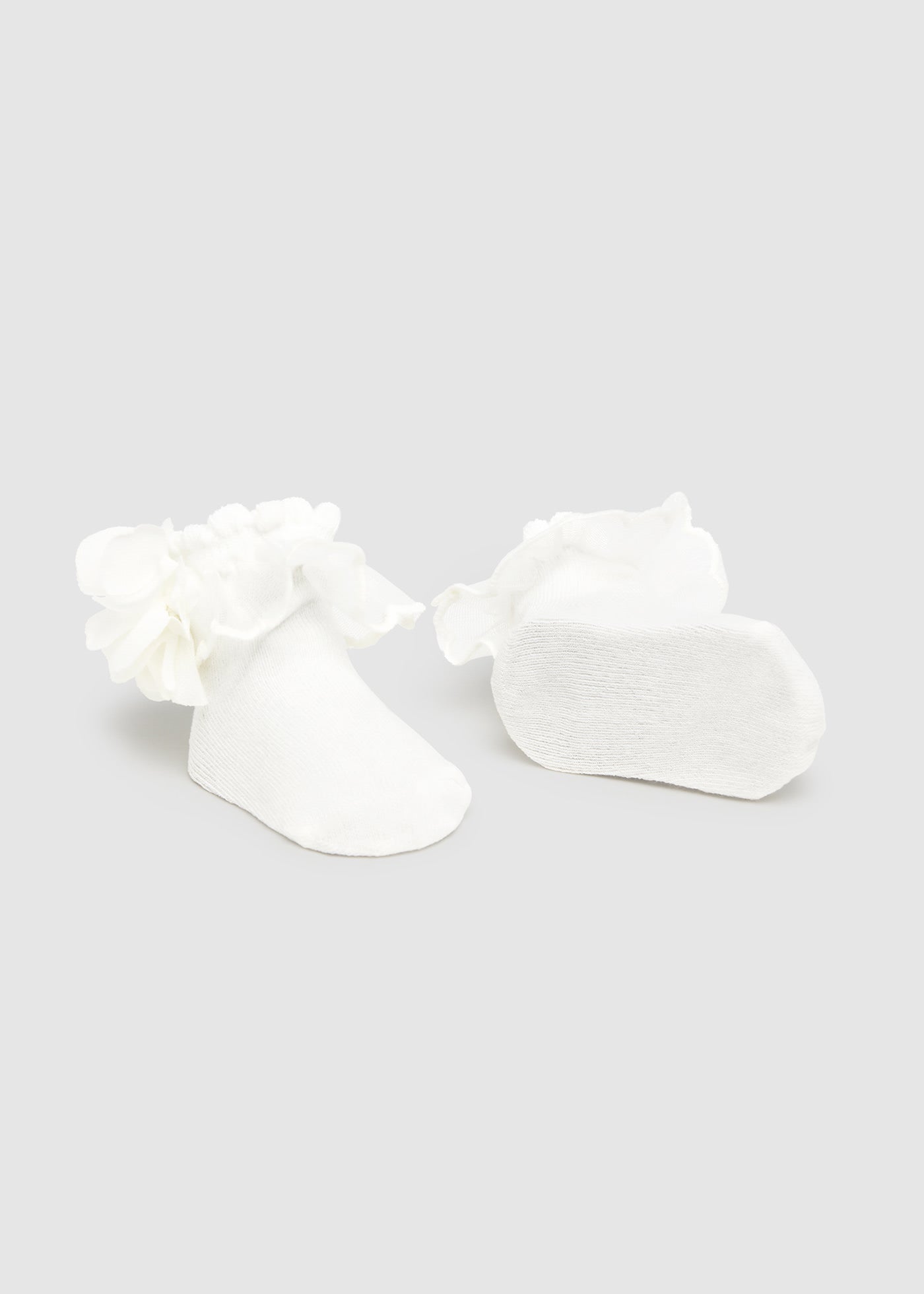 White floral earrings on a light gray background