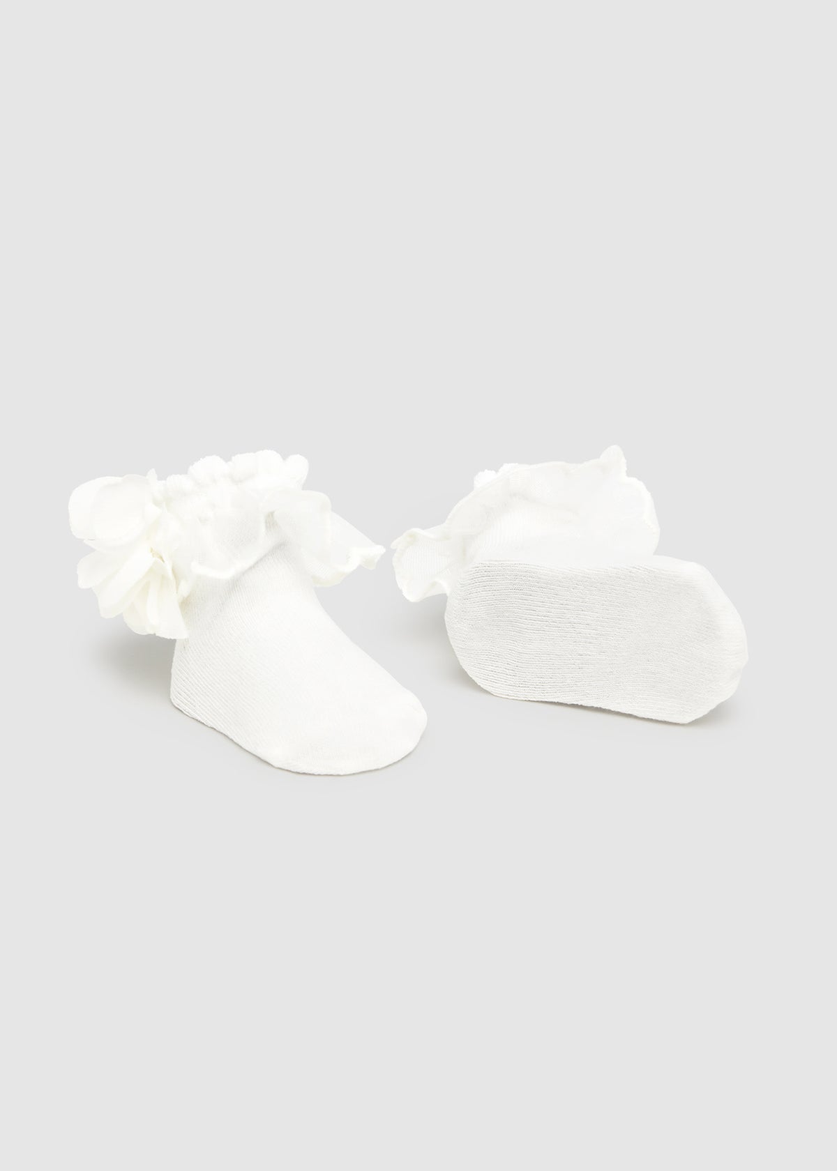 White floral earrings on a light gray background