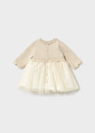 A baby girl's long-sleeve dress with a beige knit bodice and a cream tulle skirt, shown against a light gray background.