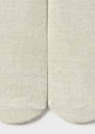 Close-up of beige socks on a light gray background