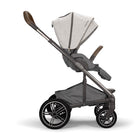 A modern baby stroller in a dark gray and light beige heathered fabric, shown from a side profile on a clean white background.