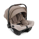 A baby car seat in a taupe-beige fabric with a black base and handle, shown from a three-quarter angle on a white background.