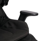 Close-up of a black ergonomic office chair showing the textured fabric seat, armrest, and part of the headrest against a white background.